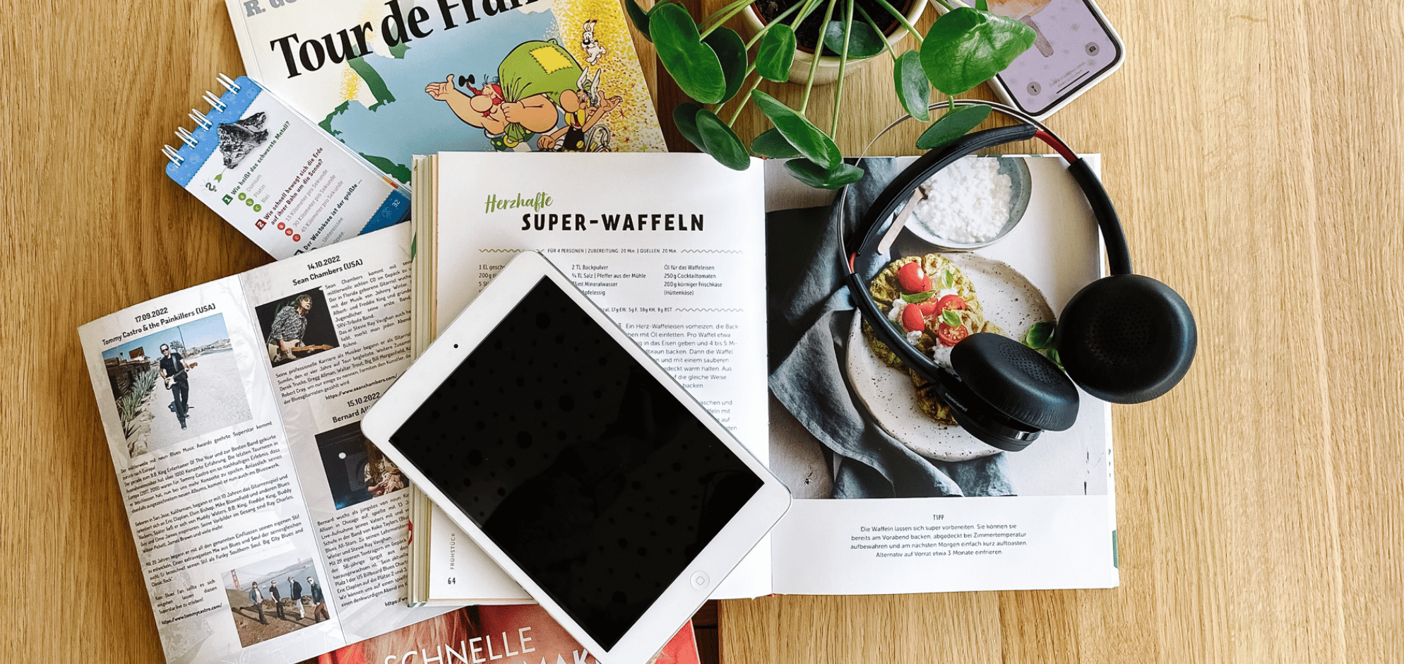 Ein Flatlay mit Büchern, Kopfhörern und Tablet.